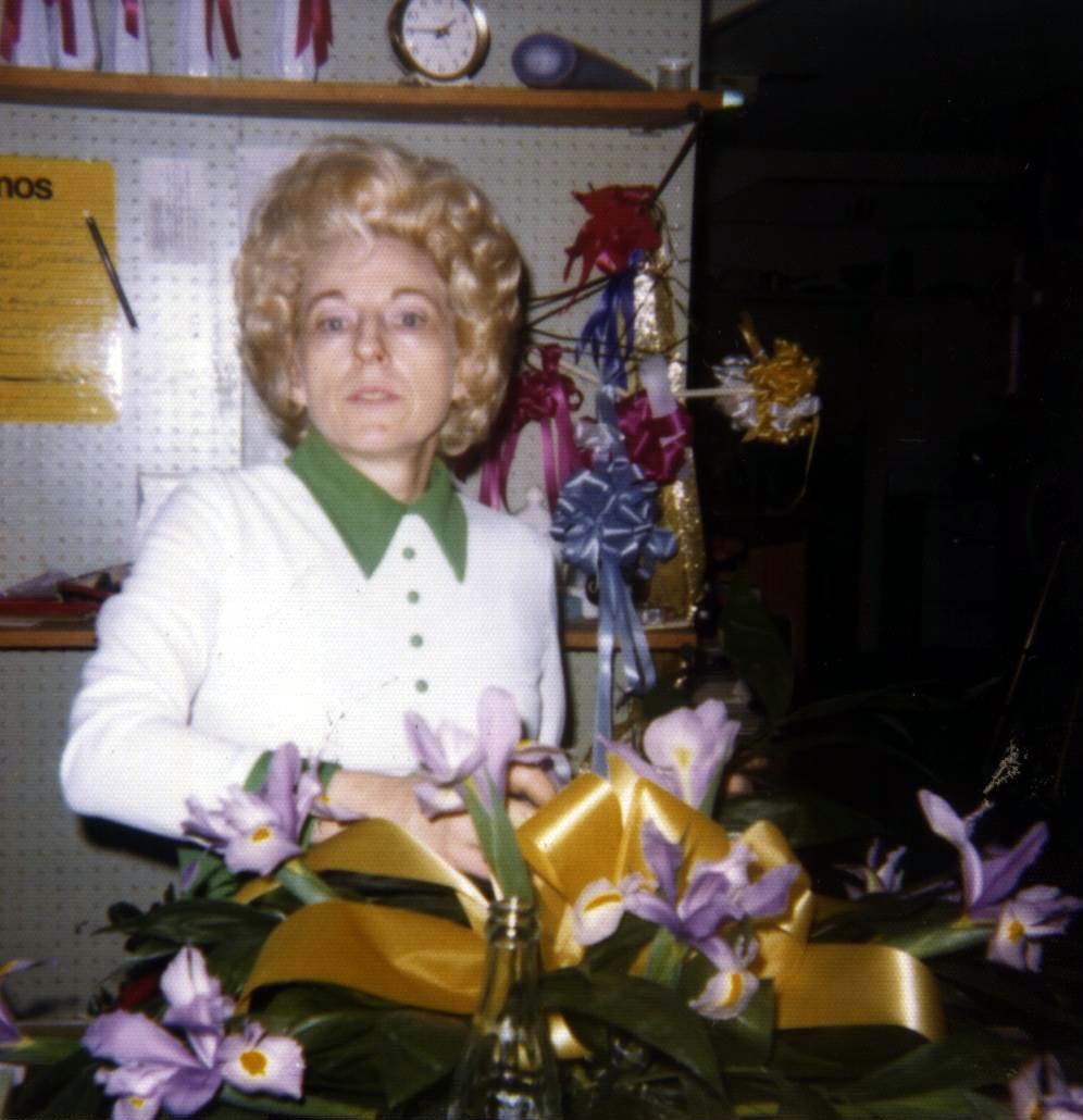 Mildred Orr, called Sissy, standing behind a spray of irises and gold ribbon in her flower shop in Houma, Louisiana.